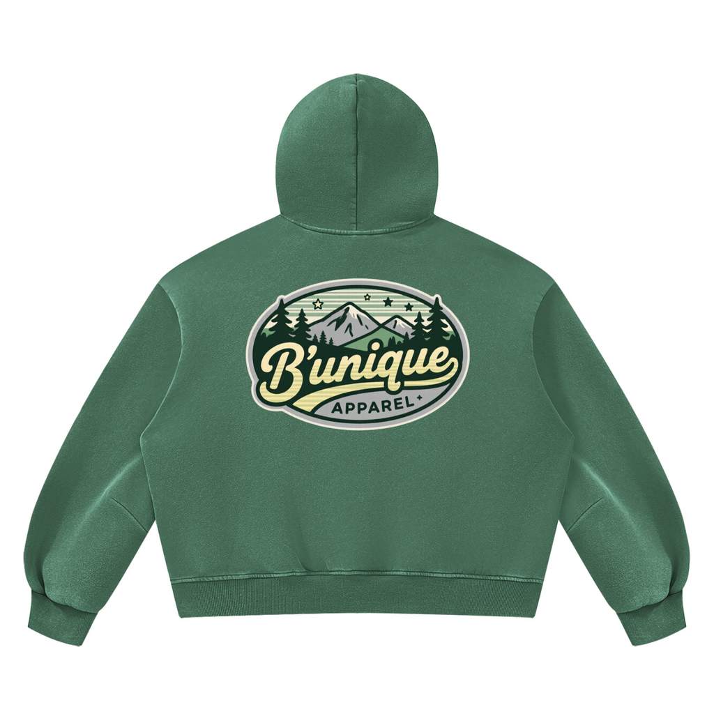 Green Unisex UNIQUE MOUTAIN Vintage Wash Boxy Fleece Hoodie featuring a back graphic of mountains, trees, and the text Bunique APPAREL.
